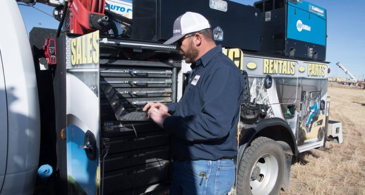 A Heavy Equipment Maintenance Specialist From ASCO Equipment Performs Diagnostics On A Wheel Loader.