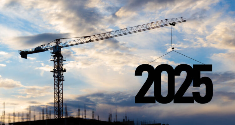 Silhouette of a construction crane against a blue cloudy sky, raising the number 2025 into the air.