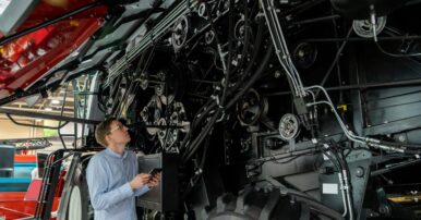 A parts & service professional at ASCO Equipment performing planned maintenance on a tractor.