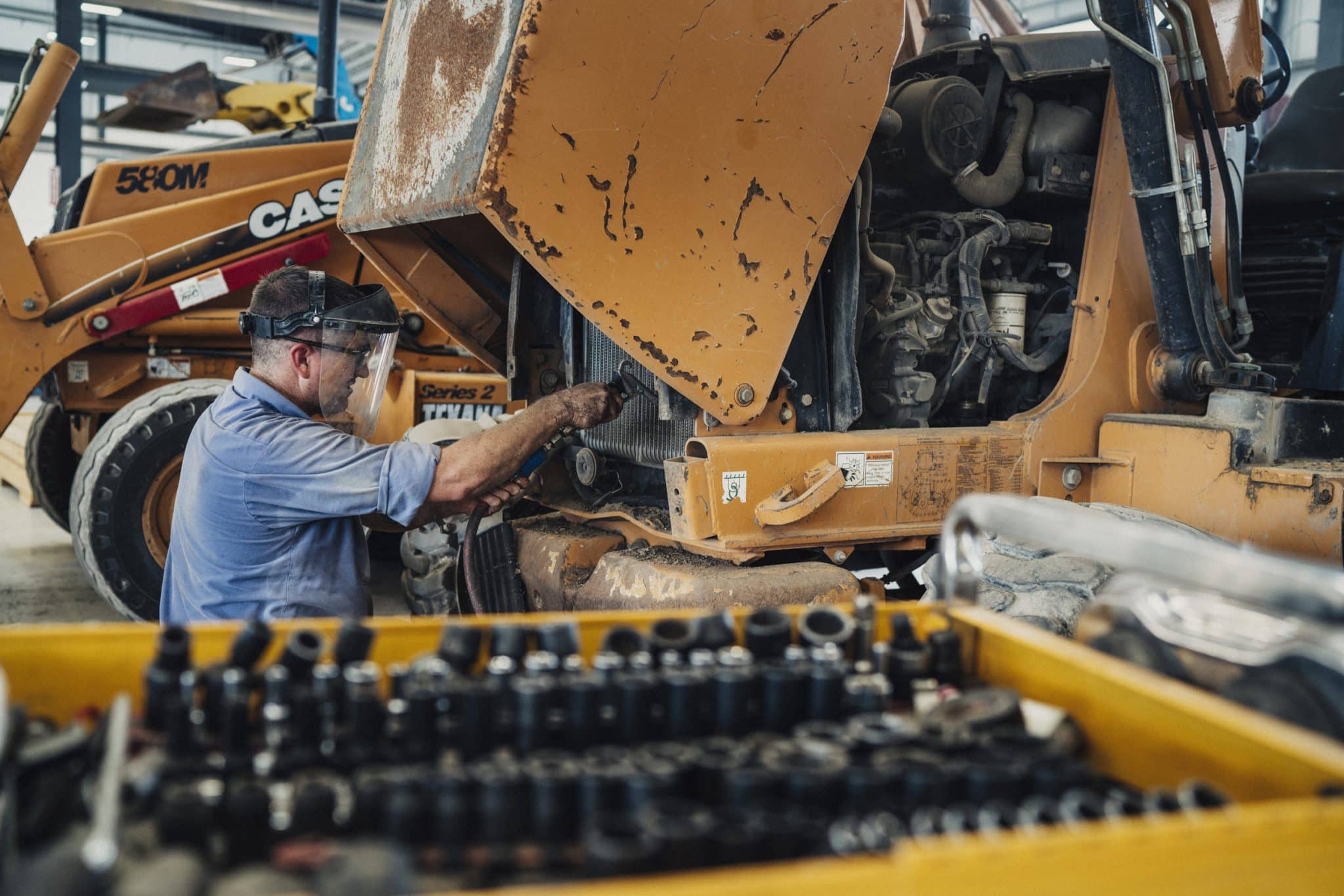 A member of ASCO Equipment’s service department performing planned maintenance on heavy equipment.