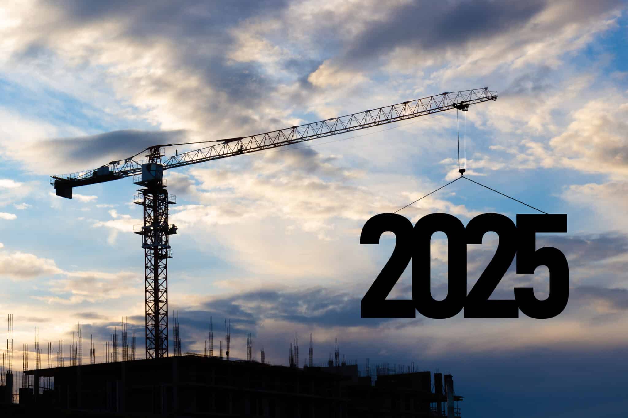 Silhouette of a construction crane against a blue cloudy sky, raising the number 2025 into the air.